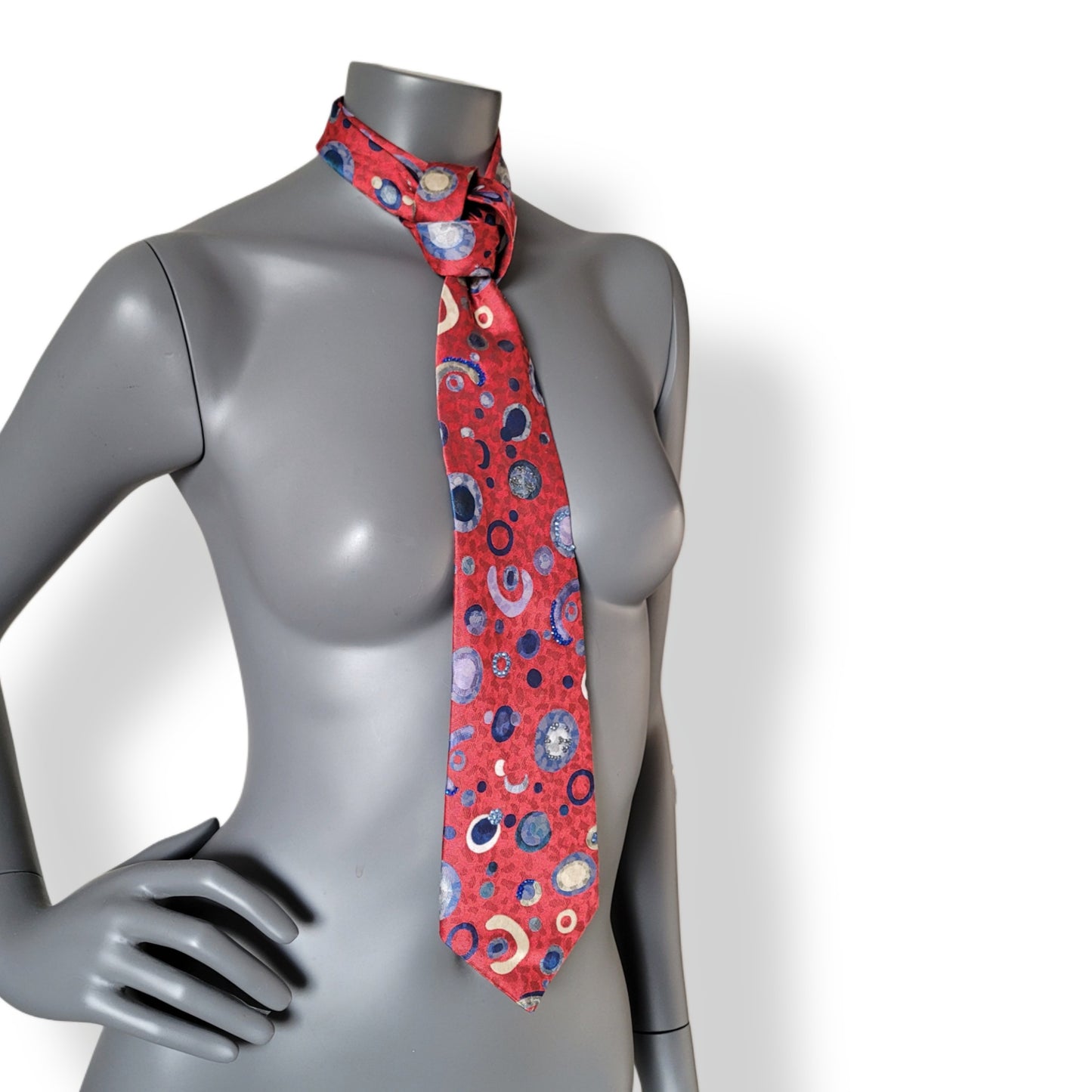 Another Dance collection: Probiotic. tie, retro 90's polyester necktie in red with round and half circular pattern in shades of blue, adorned with shimmering blue glass crystals