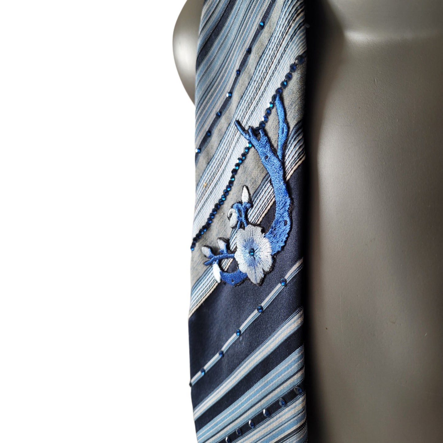 Sakura Blues collection: Sakura Rains tie, striped necktie in shades of blue and white adorned with embroidered cherry blossom appliques and blue glass crystals